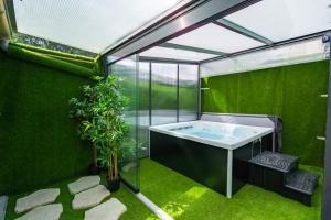 a bathroom with a tub in a green wall at Capsule Océan 2 Chambres- Billard - Jacuzzi - Netflix in Valenciennes