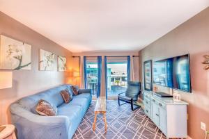 a living room with a blue couch and a chair at Gulf Shores Barefoot Bliss in Gulf Shores