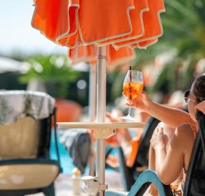 a woman sitting at a table with a drink at Bibione Palace Hotel in Bibione