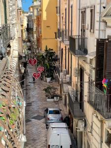 a narrow street with cars parked in a city at Guiscardo Suites in Bari