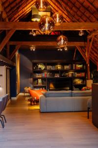 a living room with a couch and a table at Luxe Veluwse Bosrand Suite met Jacuzzi en Zwembad in Lunteren +35 photos