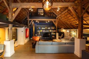 a living room with a couch and a tv at Luxe Veluwse Bosrand Suite met Jacuzzi en Zwembad in Lunteren