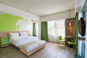 una camera con un letto bianco e una parete verde di MaxOneHotels at Bukit Jimbaran a Jimbaran