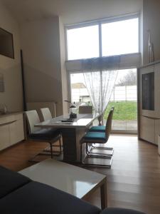 a living room with a table and chairs and a large window at Maison en sortie d'autoroute A31 in Rolampont