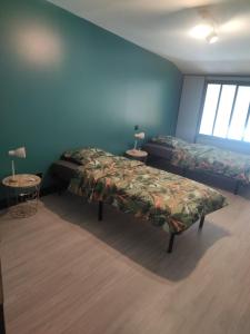 a bedroom with two beds and two tables with lamps at Maison en sortie d'autoroute A31 in Rolampont
