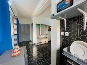 a kitchen with a sink and a refrigerator at CAMERHOME "Low Cost" in Douala