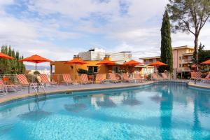 a large swimming pool with chairs and umbrellas at Hesperia Mallorca in Palma de Mallorca
