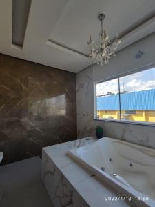 a bathroom with a tub and a large window at Loft dos sonhos cobertura in Boa Vista +57 photos