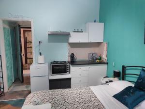 a kitchen with white cabinets and a bed in a room at Blue Dreams in Veria