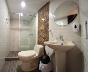 a bathroom with a toilet and a sink and a shower at Hotel San Marcos Las Lajas in Ipiales