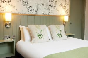 a bedroom with a bed with white sheets and pillows at Castle Inn by Greene King Inns in Bakewell