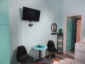 a living room with two chairs and a table and a tv at Blue Dreams in Veria