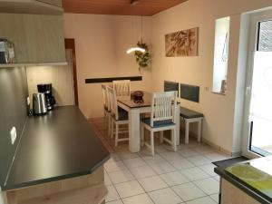 a kitchen with a table and chairs in a kitchen at Ferienwohnung Leni mit Balkon in Maroldsweisach