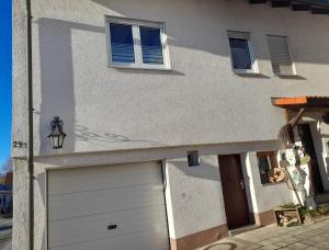a building with a garage door and two windows at Ferienwohnung Leni mit Balkon in Maroldsweisach