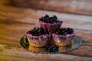 a plate with three cupcakes with blackberries on it at Tony's House Eco Hostel in Huaraz
