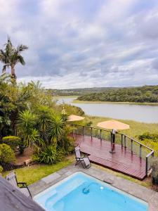 a swimming pool and deck with a view of a river at Bonza Bay Bliss in East London