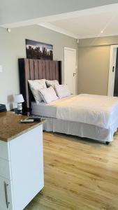 a bedroom with a large bed and a wooden floor at Bonza Bay Bliss in East London