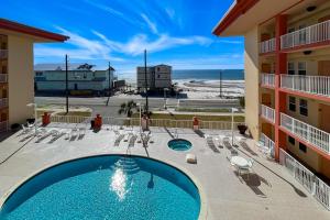 a view of the pool and beach from the balcony of a resort at Paradise Shores 305 in Mexico Beach