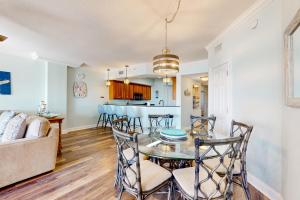 a dining room and living room with a table and chairs at Paradise Shores 305 in Mexico Beach