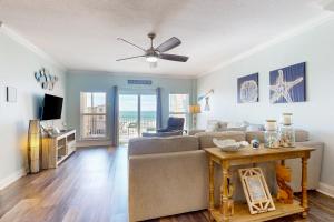 a living room with a couch and a ceiling fan at Paradise Shores 305 in Mexico Beach