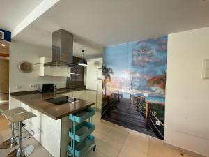 a kitchen with a large painting on the wall at Terrasol Torrelitoral Ático 1 Dormitorio in Torre del Mar +6 photos