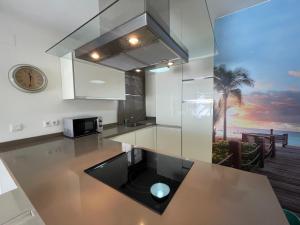 a kitchen with a counter top with a view of the ocean at Terrasol Torrelitoral Ático 1 Dormitorio in Torre del Mar