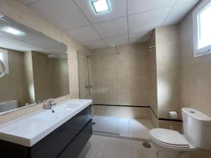 a bathroom with a sink and a toilet and a mirror at Terrasol Torrelitoral Ático 1 Dormitorio in Torre del Mar