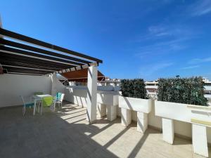 a balcony with a table and chairs on a building at Terrasol Torrelitoral Ático 1 Dormitorio in Torre del Mar