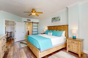 a bedroom with a bed and a ceiling fan at Paradise Shores 305 in Mexico Beach