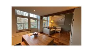a living room with a table and a couch at Chambre d'Hôtes Les Augustins - Parking sécurisé - Borne de recharge in Huy