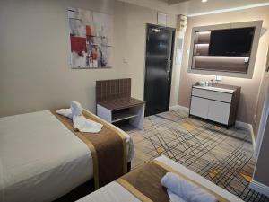 a hotel room with two beds and a television at Double bedroom studios in Dublin