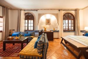 a large living room with blue furniture and windows at Dar Arraha Ouirgane in Ouirgane