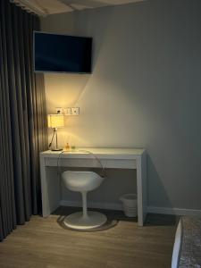 a desk with a chair and a television on a wall at Herdade do Serra in Ervidel