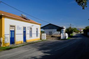 an empty street next to a yellow and white building at Pensão Destino in Castelo de Vide