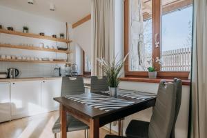 a kitchen and dining room with a wooden table and chairs at WHY NOT Apartament Krywań in Kościelisko