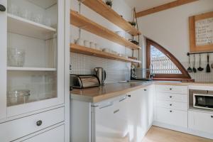 a kitchen with white cabinets and a counter at WHY NOT Apartament Krywań in Kościelisko