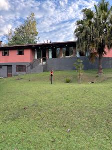 a person standing in a yard in front of a house at Chacára Reni in Itajubá