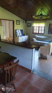 a room with a table and a bed in a room at Chacára Reni in Itajubá