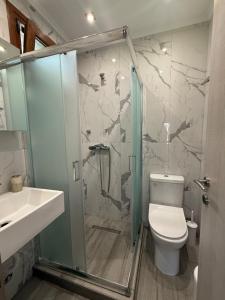 a bathroom with a shower and a toilet and a sink at Victoria's Apartments in Nea Plagia +28 photos