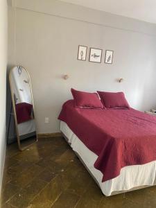 a bedroom with a large bed and a mirror at Flat na beira da praia in Maricá