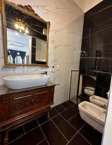 a bathroom with a sink and a toilet and a mirror at Guiscardo Suites in Bari
