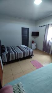 a bedroom with a bed and a television in it at Pousada Central in Montes Claros