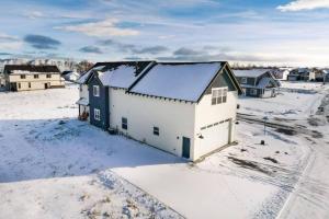an aerial view of a white building in the snow at Lulu’s Family Lakehouse in Garden City