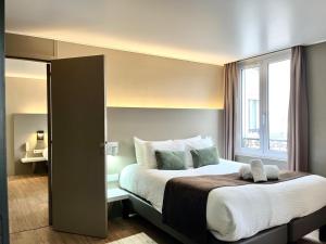 a bedroom with a large bed with a window at HOTEL & SPA Le Renard Centre in Chalons en Champagne +71 photos