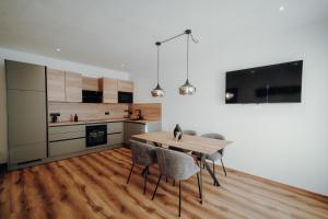 a kitchen and dining room with a wooden table and chairs at Kleinberg Chalet in Filzmoos +10 photos