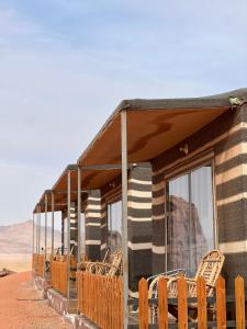 a group of chairs sitting outside of a building in the desert at Golden Stars Luxury Camp Wadi Rum in Wadi Rum