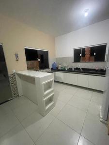 a large kitchen with a white counter in a room at Dunas Exclusive in Santo Amaro