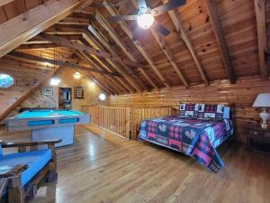 a bedroom with a bed in a log cabin at Mountain Rose- Hot Tub, Pool Table, Firepit in Stanton