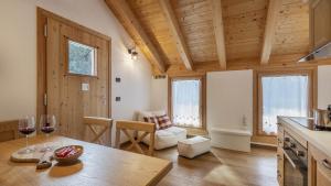 a kitchen with a table and two wine glasses at Chalet Les Combes in Ponte di Legno