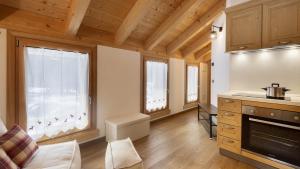 a large kitchen with wooden ceilings and windows in a house at Chalet Les Combes in Ponte di Legno +34 photos